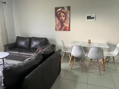 a living room with a couch and a table at Warm, Homely Apartment - 5min Away Menlyn Main in Pretoria