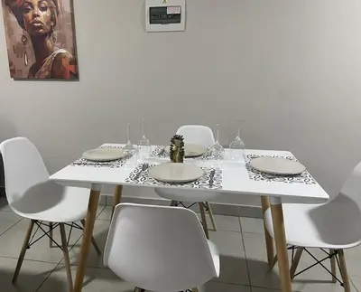 a white table with white chairs and a table with plates at Warm, Homely Apartment - 5min Away Menlyn Main in Pretoria