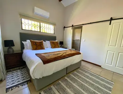 a bedroom with a large bed and a window at Park View - Creature comforts in nature in Marloth Park