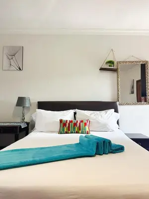 a large white bed with a blue blanket on it at Tsheryl's Residence in Centurion