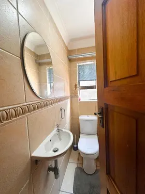 a bathroom with a toilet and a sink and a mirror at Tsheryl's Residence in Centurion