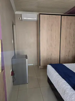 a bedroom with a bed and a sliding door at Limpopo LidoSystem Lodge