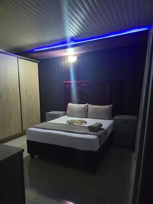 a bedroom with a bed with a blue light on it at Limpopo LidoSystem Lodge