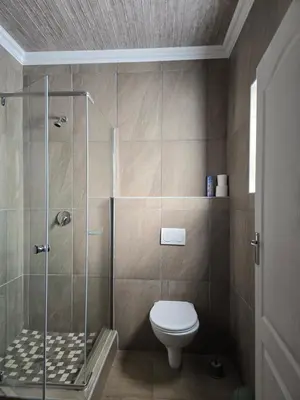 a bathroom with a shower and a toilet at Limpopo LidoSystem Lodge