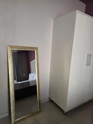 a mirror sitting next to a white cabinet with a sink at Limpopo LidoSystem Lodge