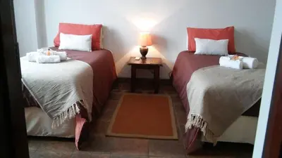 a room with two beds and a lamp on a table at Ilane Guesthouse in Nelspruit