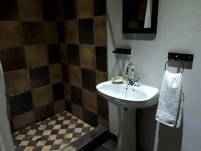 a bathroom with a sink and a tiled wall at Ilane Guesthouse in Nelspruit