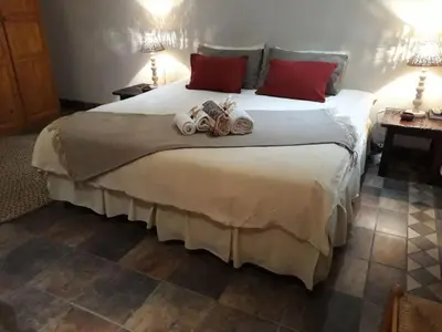 a bedroom with a large bed with towels on it at Ilane Guesthouse in Nelspruit