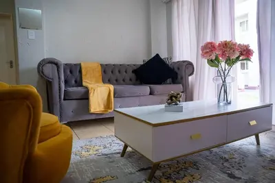 a living room with a purple couch and a coffee table at Modern Tranquility in Benoni