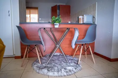 two chairs sitting at a bar with a table at Modern Tranquility in Benoni