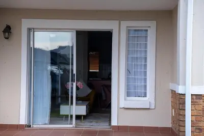 a sliding glass door of a house with a window at Modern Tranquility in Benoni