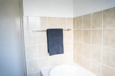 a bathroom with a toilet and a blue towel at Modern Tranquility in Benoni