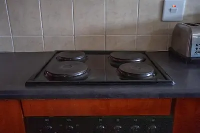 a stove top with three burners on it in a kitchen at Modern Tranquility in Benoni