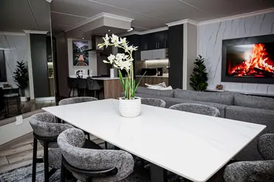 a dining room with a white table and chairs at Walton Luxe Retreat in Midrand