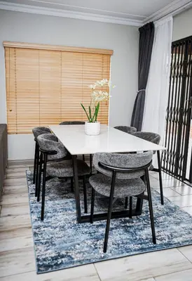 a dining room with a white table and chairs at Walton Luxe Retreat in Midrand