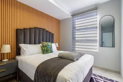 a bedroom with a large bed and a window at The Manson's BishopsCourt in Pretoria