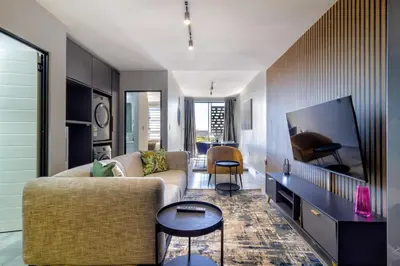 a living room with a couch and a flat screen tv at The Manson's BishopsCourt in Pretoria