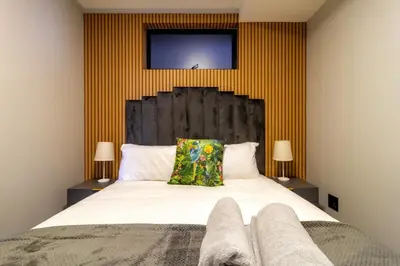 a bedroom with a large white bed with yellow stripes at The Manson's BishopsCourt in Pretoria