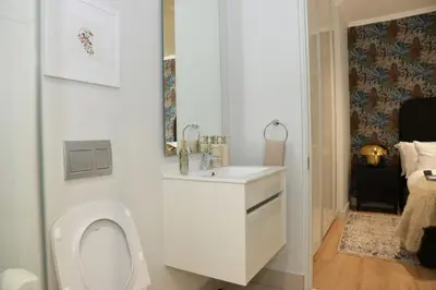 a white bathroom with a toilet and a sink at Ellipse Olive and Vine in Midrand