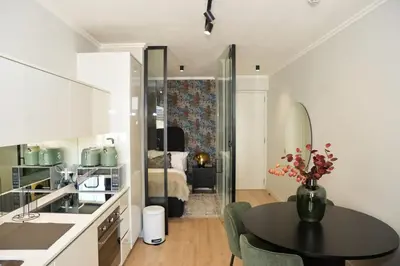 a kitchen and living room with a table and a bedroom at Ellipse Olive and Vine in Midrand