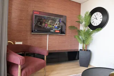 a living room with a tv on a wall at Ellipse Olive and Vine in Midrand