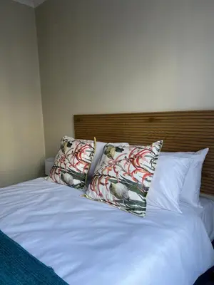 a bed with two pillows on top of it at The West End 252 in Midrand