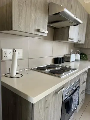 a kitchen with a stove and a counter top at The West End 252 in Midrand