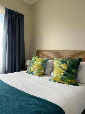 a bedroom with a bed with two pillows on it at The West End 252 in Midrand