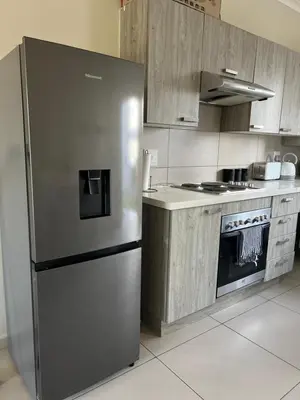 a kitchen with a stainless steel refrigerator and a stove at The West End 252 in Midrand
