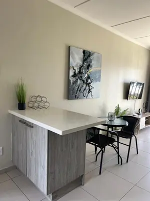 a kitchen with a counter and a table and chairs at The West End 252 in Midrand