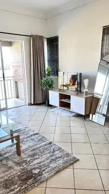 a living room with a tv and a tiled floor at Luxury Lakeview Retreat in Pretoria