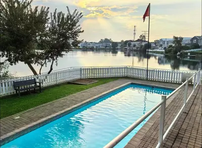 a swimming pool next to a body of water at Luxury Lakeview Retreat in Pretoria
