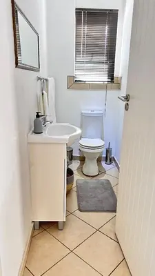 a bathroom with a white toilet and a sink at Luxury Lakeview Retreat in Pretoria