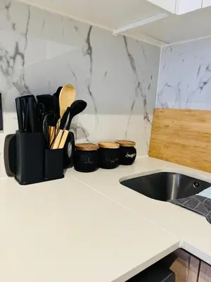 a kitchen counter with a sink and some utensils at Shezi Cozy Home at The Blyde in Pretoria