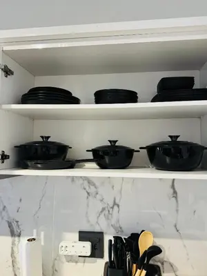 a shelf filled with black bowls and plates at Shezi Cozy Home at The Blyde in Pretoria