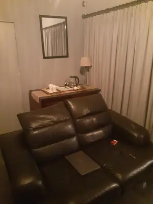 a living room with a leather couch and a desk at The Concept in Centurion