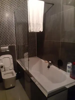 a bathroom with a white tub and a toilet at The Concept in Centurion