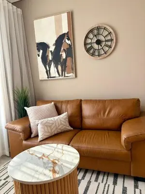 a living room with a brown couch and a table at Modern Studio in Menlyn Maine in Pretoria