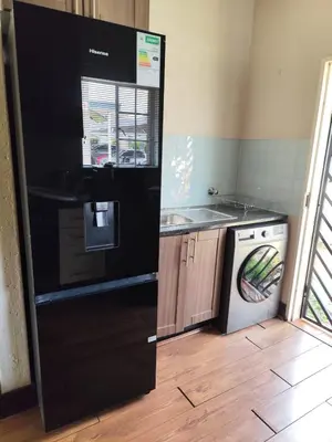 a kitchen with a black refrigerator and a dishwasher at Aspen Creek in Benoni