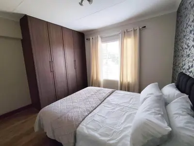 a bedroom with a white bed and a window at Aspen Creek in Benoni