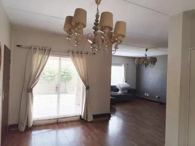 a living room with a chandelier and a large window at Aspen Creek in Benoni