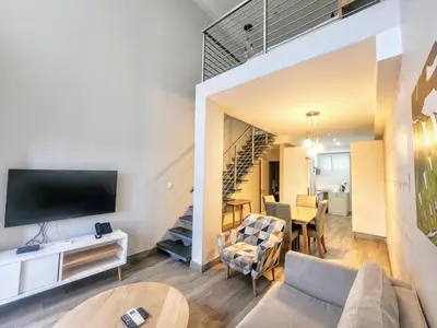 a living room with a couch and a tv and a table at Modern loft at Regency in Pretoria