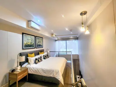 a bedroom with a bed and a window at Modern loft at Regency in Pretoria