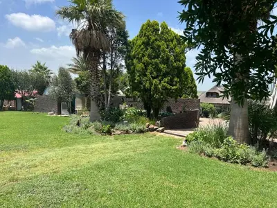 a yard with green grass and trees and a house at Doringdraad Lodge Rooms Mufasa and Simba in Brendan Village