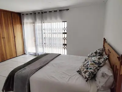 a bedroom with a large bed with a window at Doringdraad Lodge Rooms Mufasa and Simba in Brendan Village