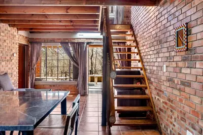 a staircase in a room with a brick wall at Timbuktwini, Marloth Park, Mpumalanga in Marloth Park