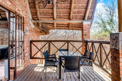 a patio with a table and chairs on a deck at Timbuktwini, Marloth Park, Mpumalanga in Marloth Park