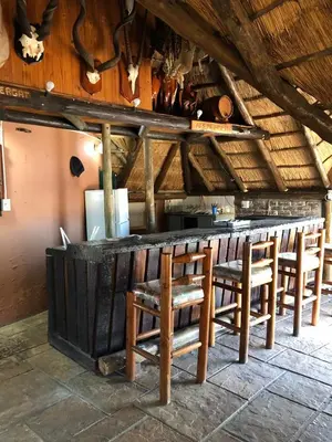 a bar with wooden chairs in a room at Doringdraad Lodge Nala and Zazu in Brendan Village