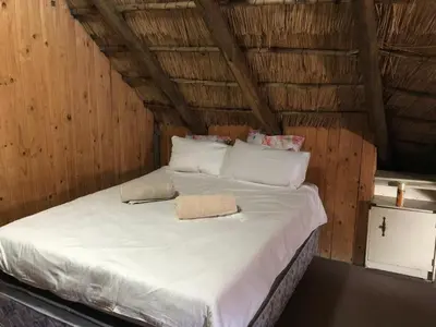 a bed in a room with white sheets and pillows at Doringdraad Lodge Nala and Zazu in Brendan Village