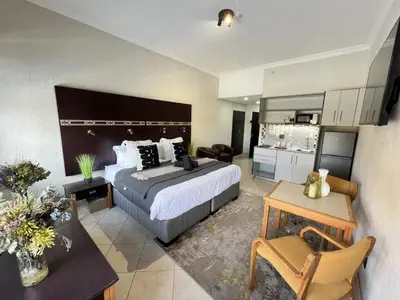 a hotel room with a bed and a table at Promenade Place Nelspruit in Nelspruit